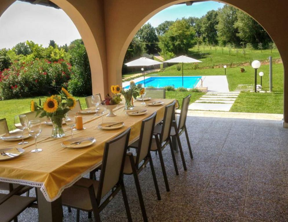 - une table pour un repas avec vue sur la piscine dans l'établissement Villa Gasco With Pool, à Lazise
