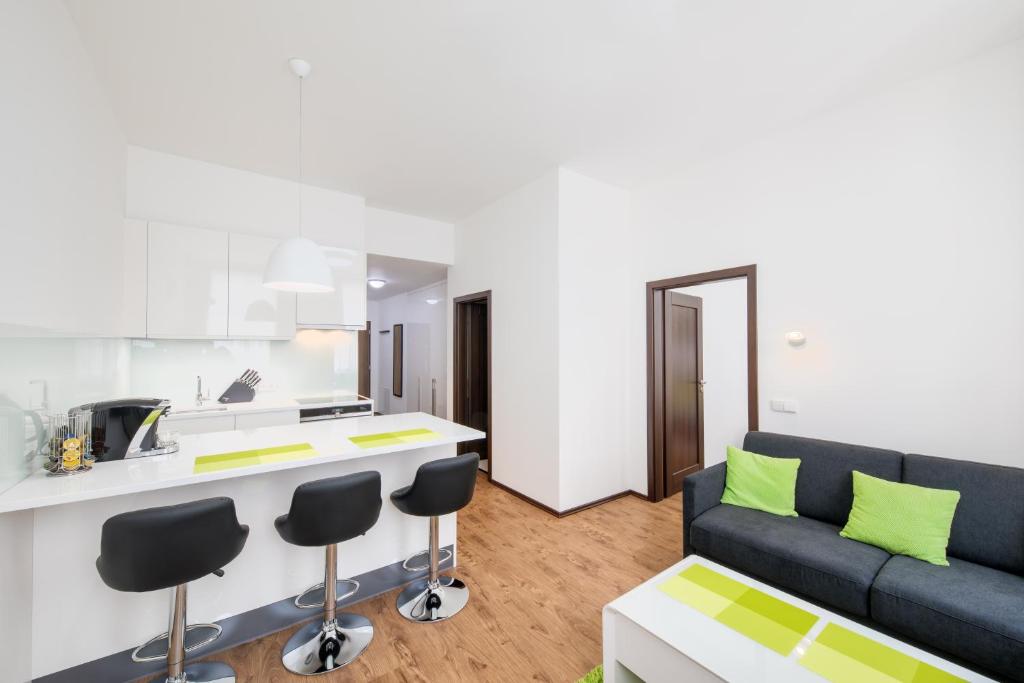 a living room with a couch and a kitchen at Apartment near city centre with parking place in Prague