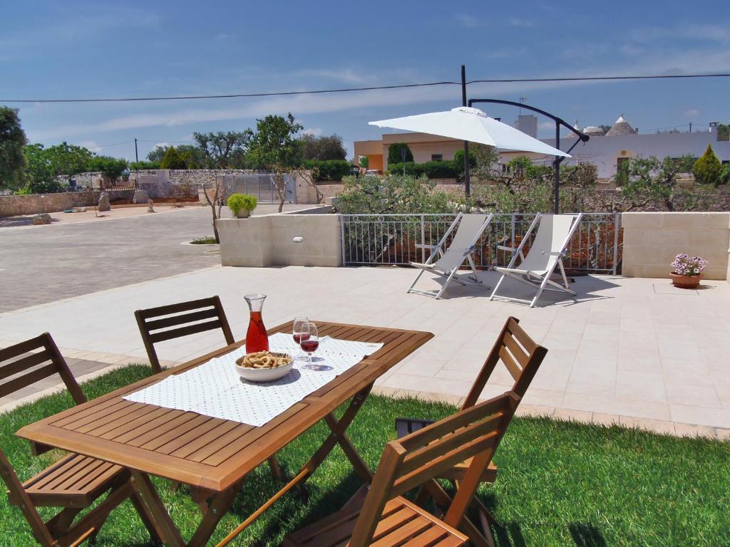 a wooden table with chairs and a table with a glass of wine at Terrazza Sui Colli in Monopoli