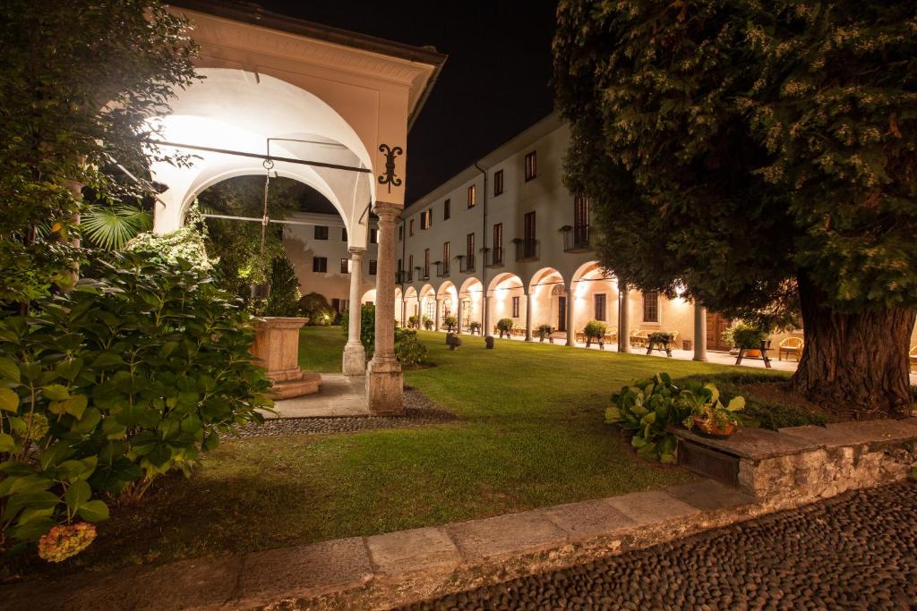 een binnenplaats van een gebouw 's nachts met een boom bij Il Chiostro in Verbania