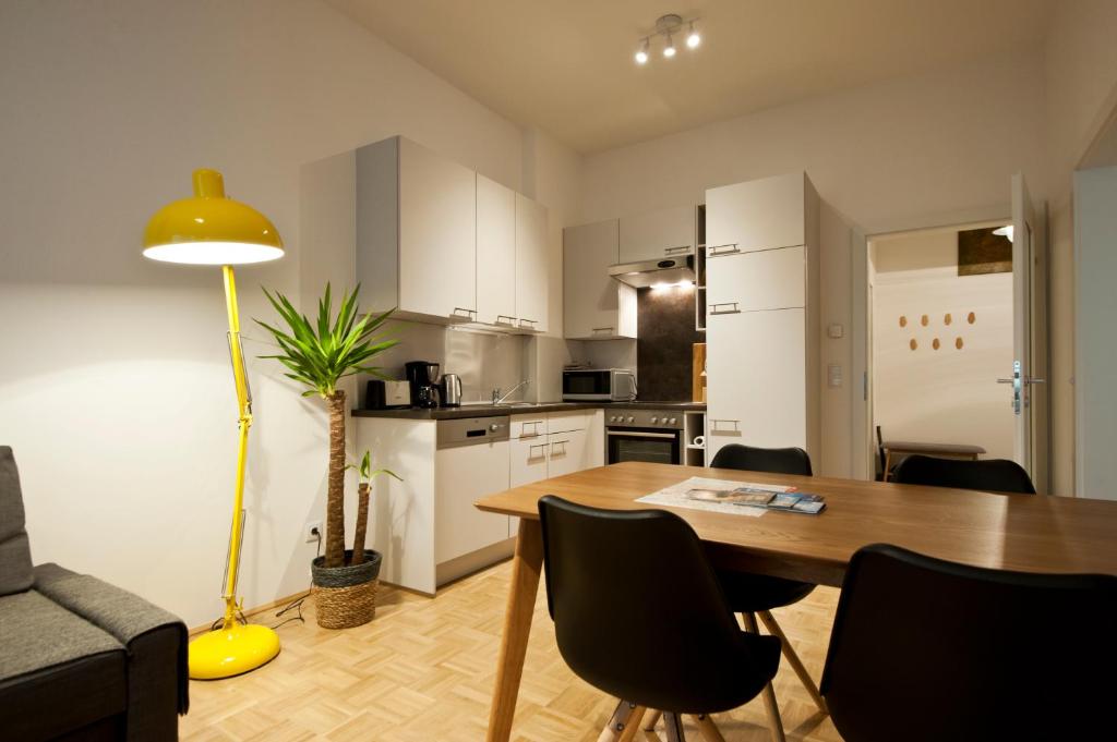 cocina y comedor con mesa y sillas en City-Apartment Neubaugasse, en Graz
