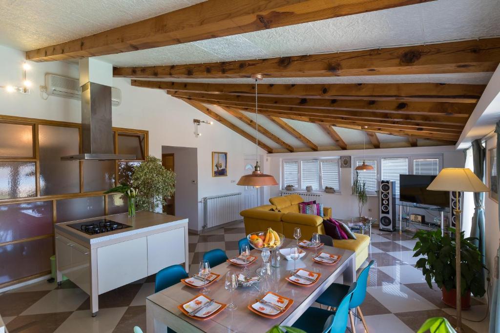 a kitchen and living room with a table and chairs at Apartments Carol Royal in Cavtat