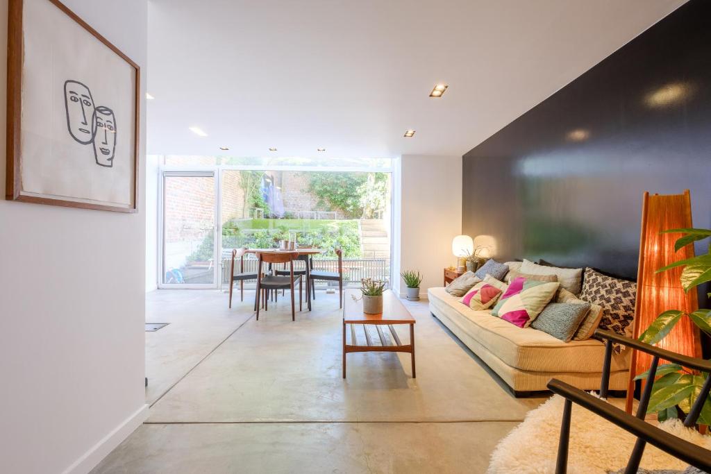 ein Wohnzimmer mit einem Sofa und einem Tisch in der Unterkunft 1bd apartment with garden Brugmann area in Brüssel