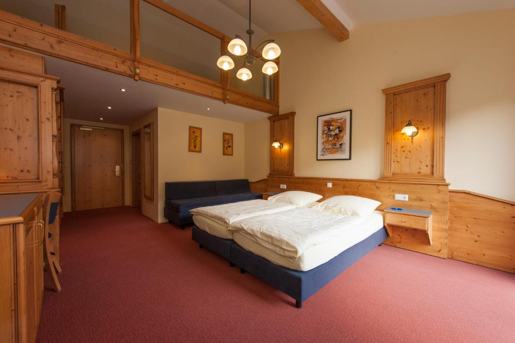 a large bedroom with a bed and a couch at Hotel Belle Vue in Vianden
