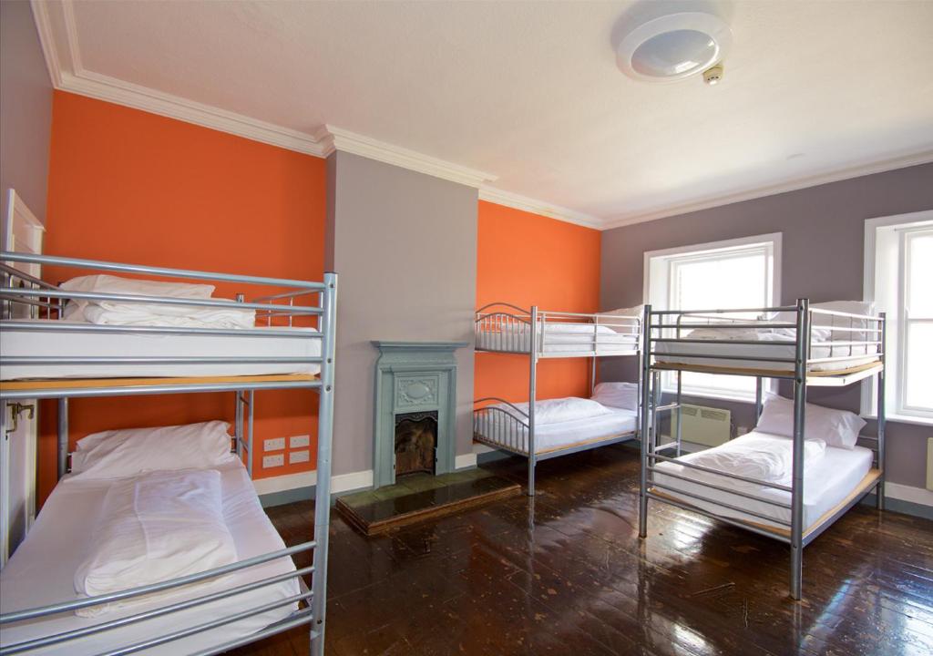 ニューカッスル・アポン・タインにあるAlbatross Hostelの二段ベッド3組と暖炉が備わる客室です。