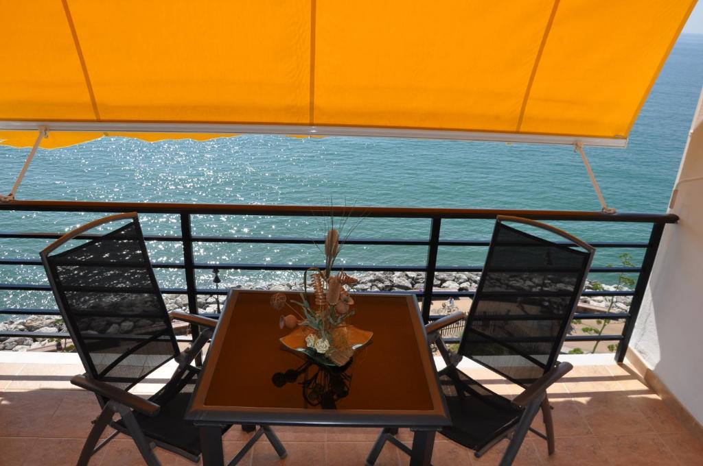 a table and two chairs on a balcony with the ocean at Studio Vue Mer in Torremolinos