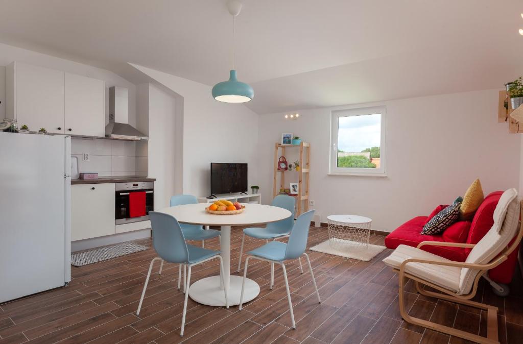 a kitchen and a living room with a table and chairs at Kvasina Apartments in Zadvarje