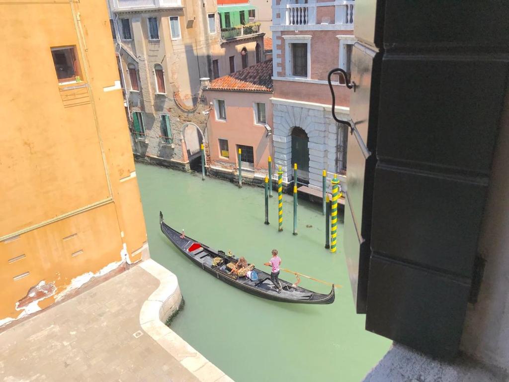 a group of people riding a gondola down a canal at Penthouse Of Venice in Venice