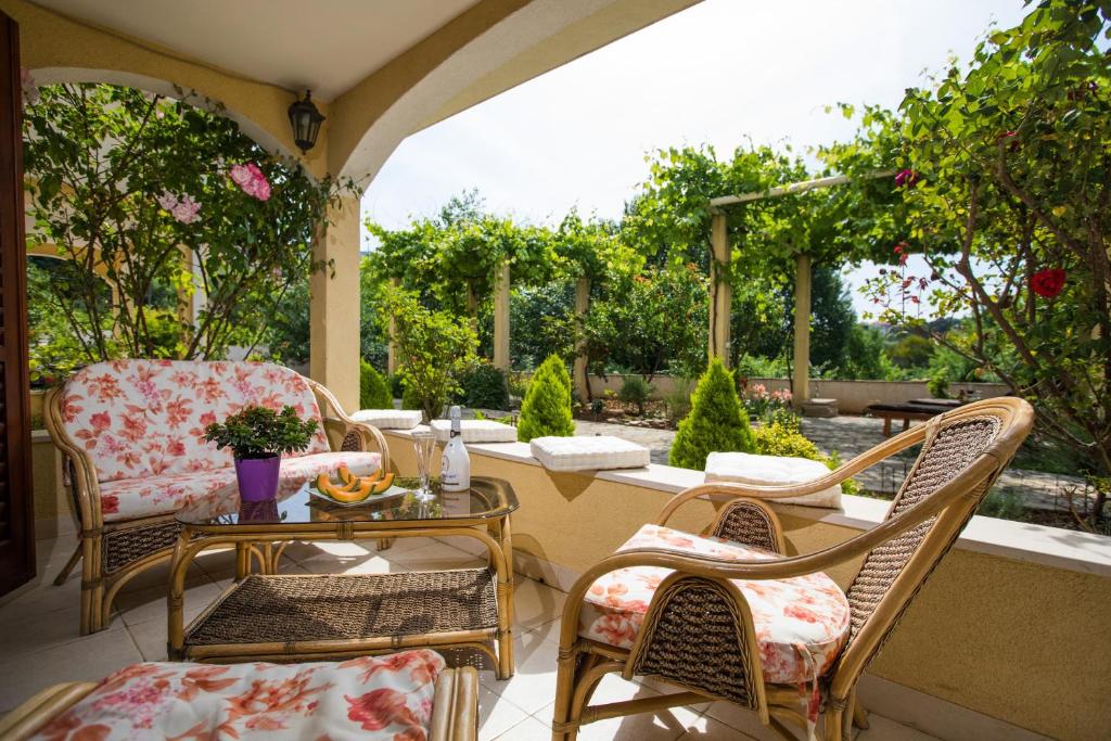 a patio with chairs and a table with a view of a garden at Madonna Guest House in Dubrovnik