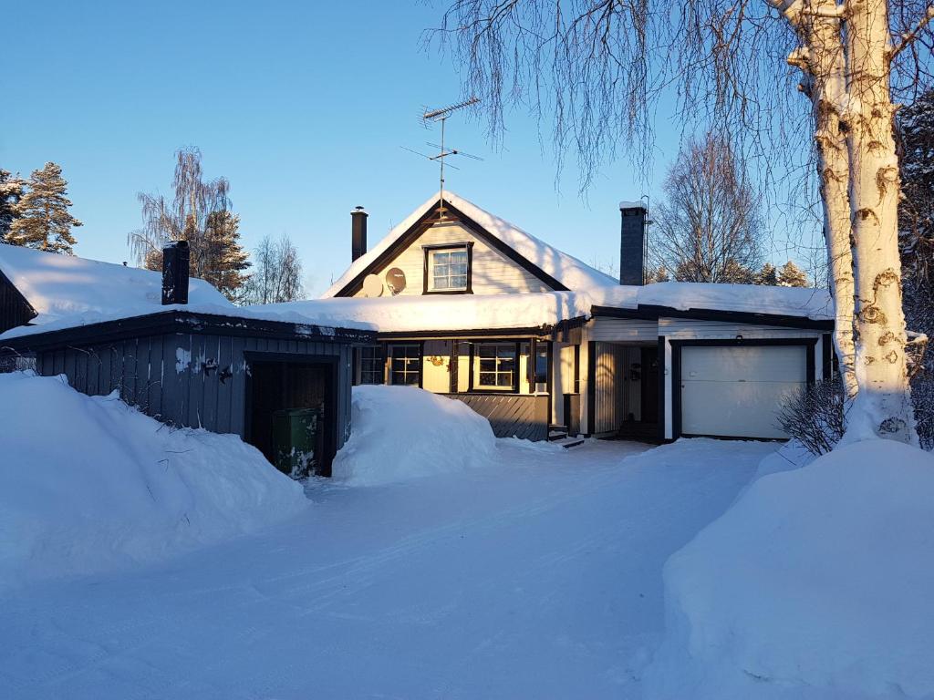 una casa está cubierta de nieve con una entrada en Villa Majringen en Vidsel