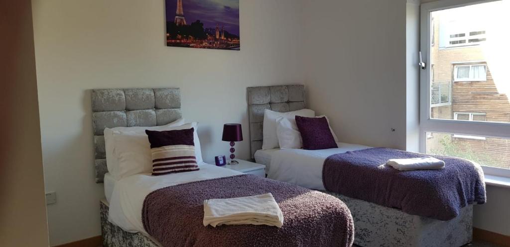 a bedroom with two beds and a window at Vetrelax Basildon City Center Apartment in Basildon