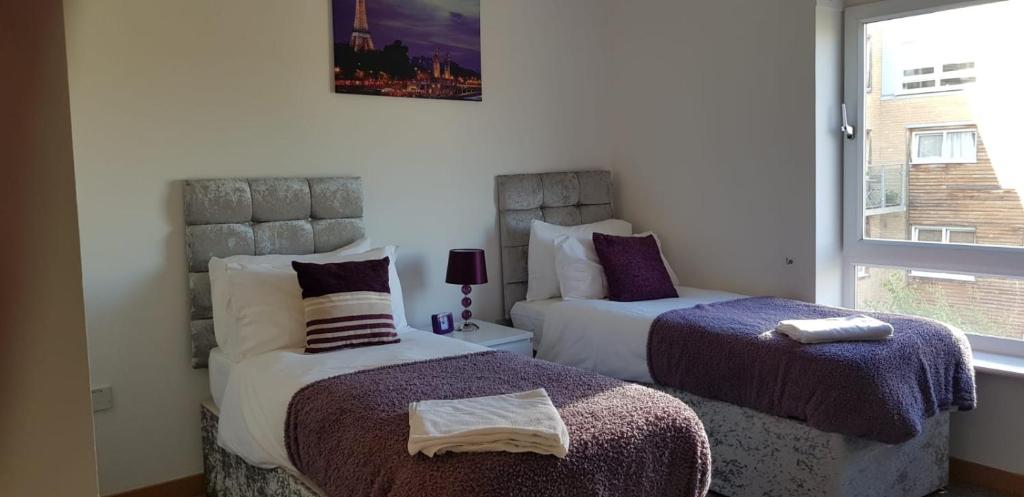 um quarto com 2 camas e uma janela em Vetrelax Basildon City Center Apartment em Basildon