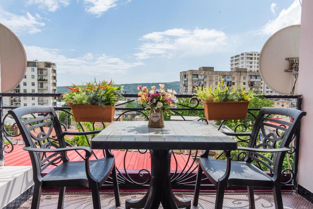 a table and chairs on a balcony with a view at Hotel S.R in Tbilisi City