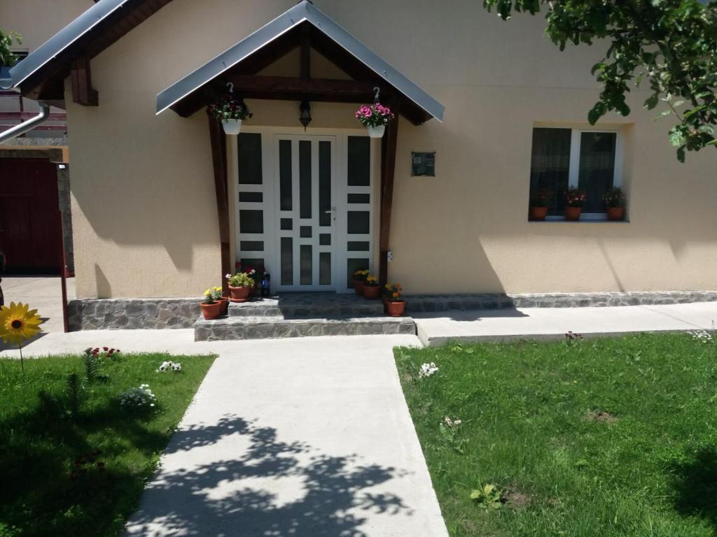una casa con una puerta blanca y un patio de césped en Casa Luca, en Buşteni