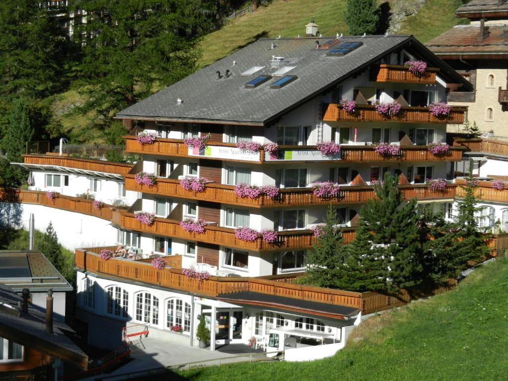 een groot gebouw met bloemen op de balkons bij Artist Apartments & Hotel Garni in Zermatt