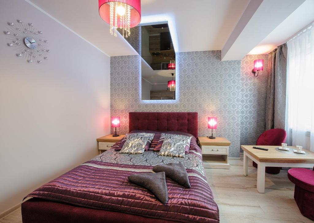 a bedroom with a large bed and a mirror at Apartamenty Crystal in Ciechocinek