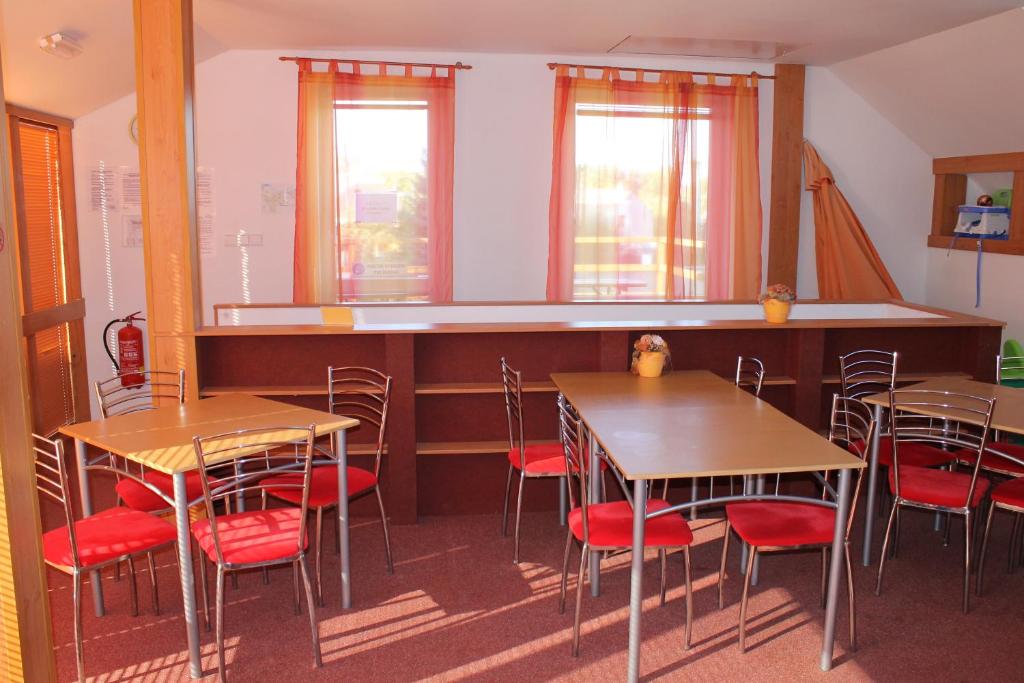 restauracja z drewnianymi stołami i czerwonymi krzesłami w obiekcie Penzion Horka w mieście Horka nad Moravou