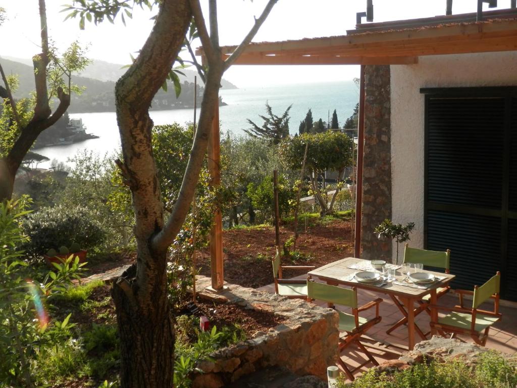 a table and chairs on a patio with a view of the ocean at Dèpendance Argentario in Porto Santo Stefano
