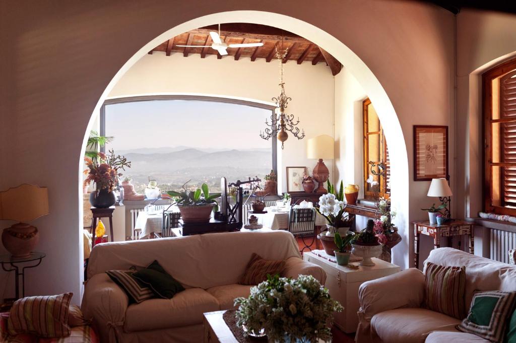 a living room with two couches and a large window at B&B La Zolla in Impruneta
