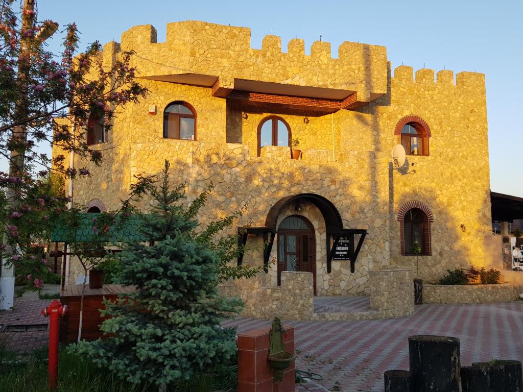 un grand bâtiment jaune avec un château dans l'établissement Royal Castle, à Paşcani