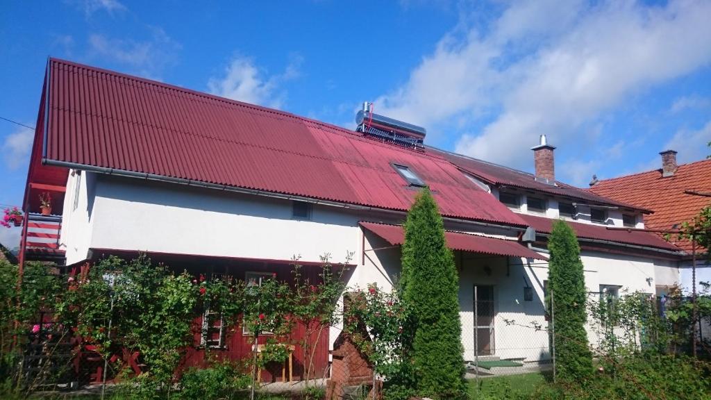 a white and red house with a red roof at Pensiunea Ivanciu Bogdan in Praid