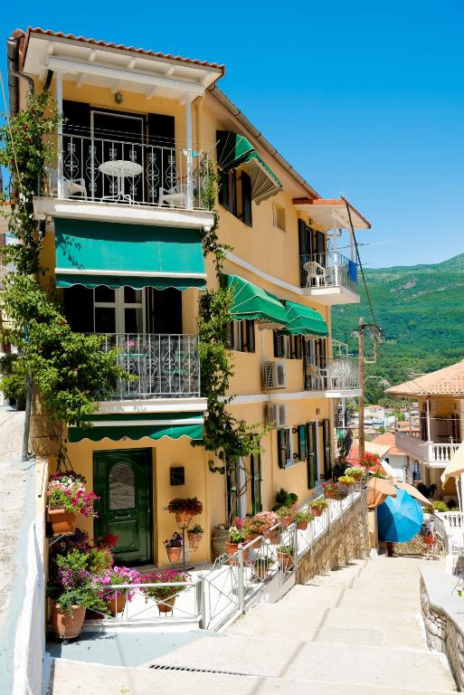 a yellow building with tables and chairs in front of it at Marina's House in Parga