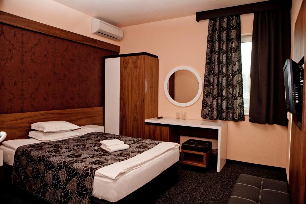 a hotel room with two beds and a mirror at Hotel Serdica in Silistra