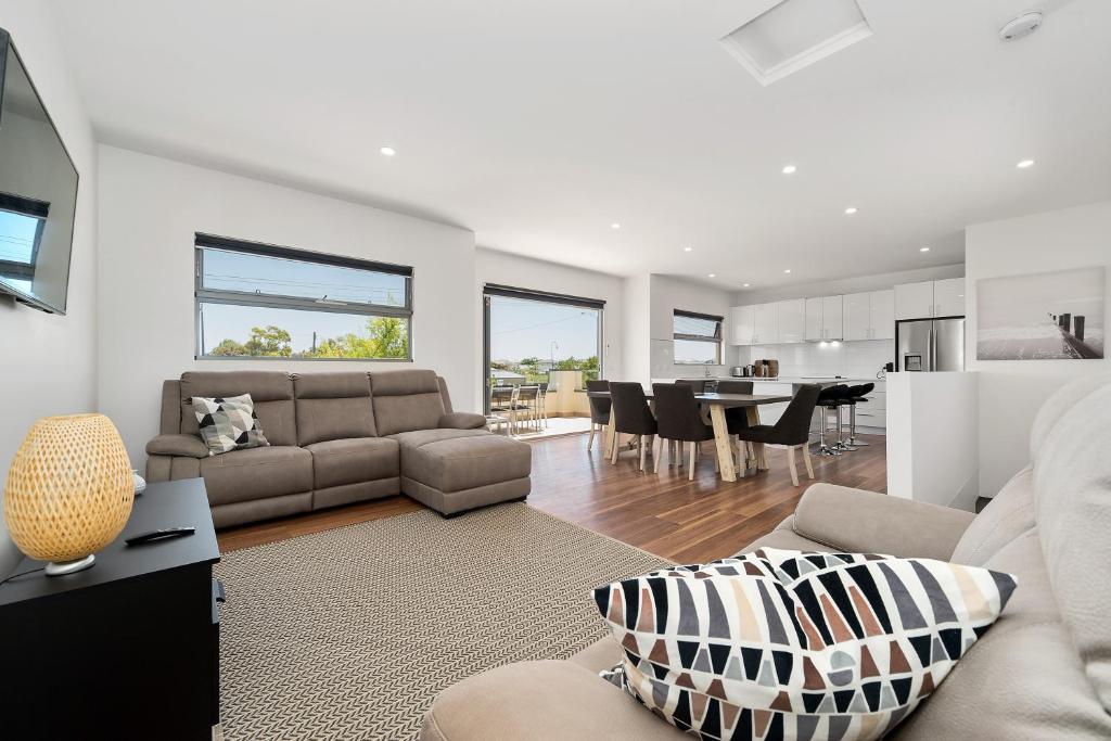 a living room with a couch and a table at Rosewater Townhouses Dromana in Dromana