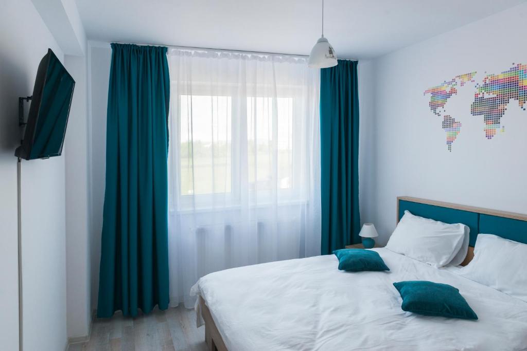 a bedroom with a bed with green curtains and a window at Friendly Rentals Brasov in Braşov