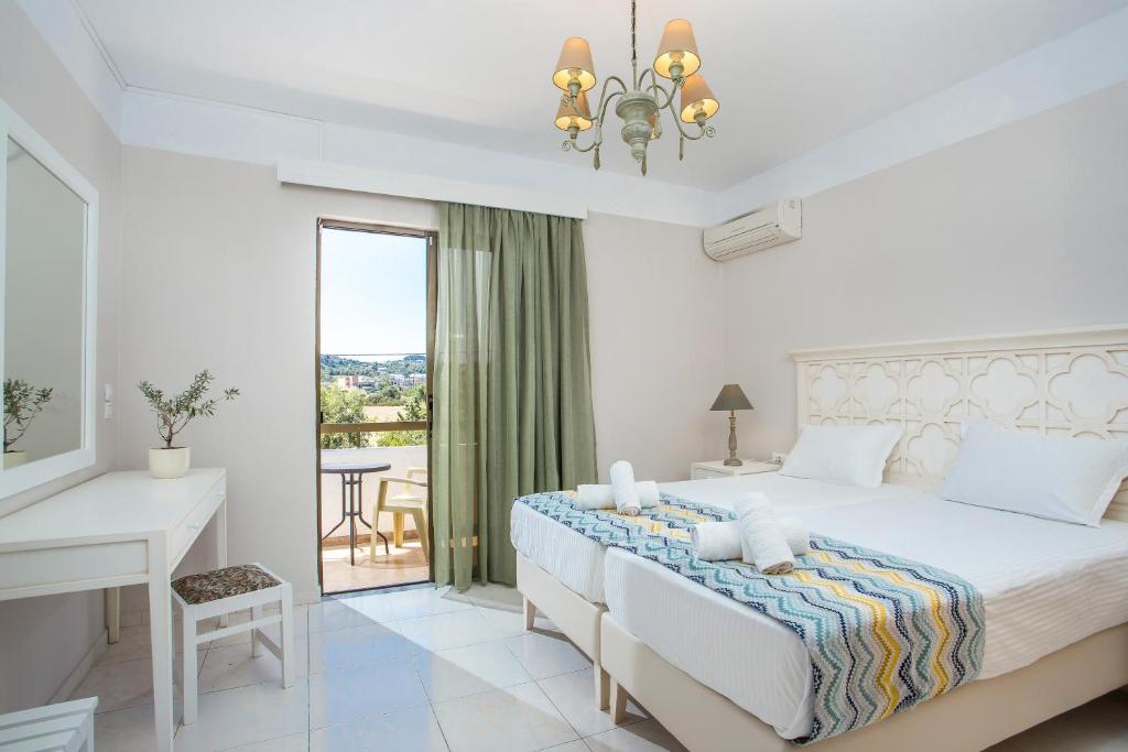a bedroom with a bed and a desk and a window at Voula Studios in Faliraki