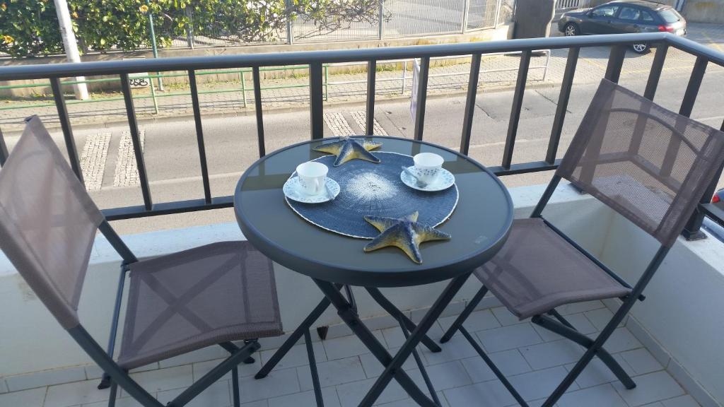 アルヴォルにあるAlvor Navy Apartmentの青いテーブルとバルコニー(椅子2脚付)