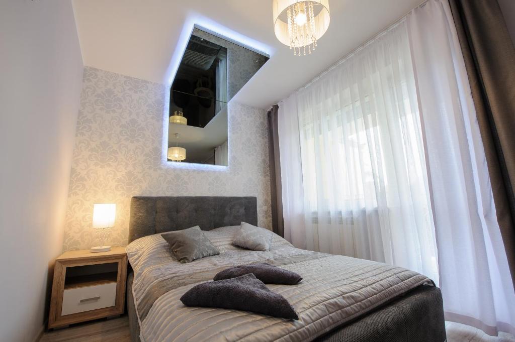 a bedroom with a bed with pillows and a mirror at Willa Krystal in Ciechocinek