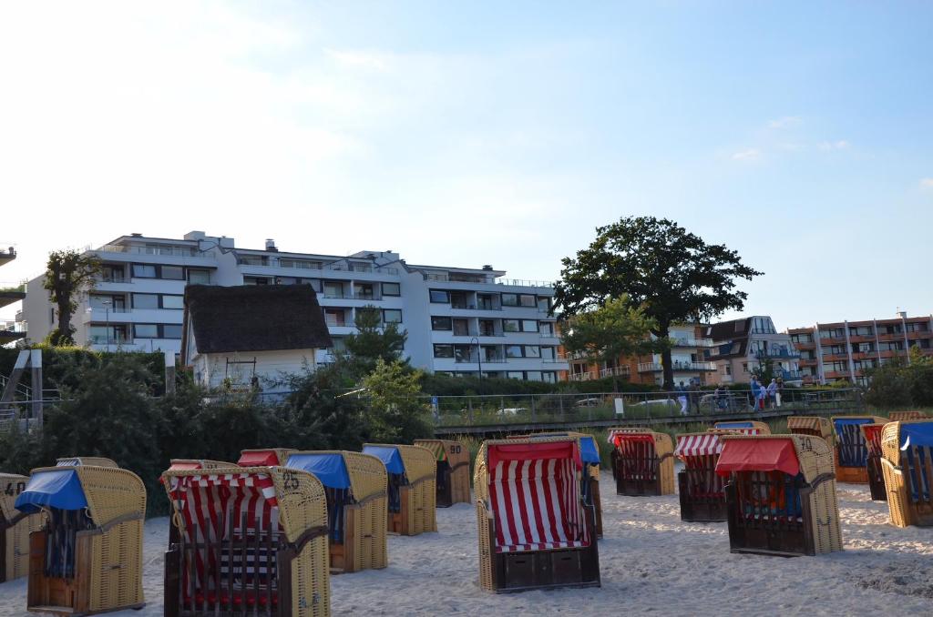 - une rangée de chaises dans le sable sur une plage dans l'établissement Hanseat Meerblick, à Scharbeutz