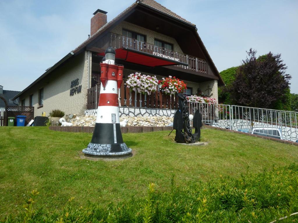 a lighthouse statue in front of a house at Ferienhaus Neptun in Carolinensiel
