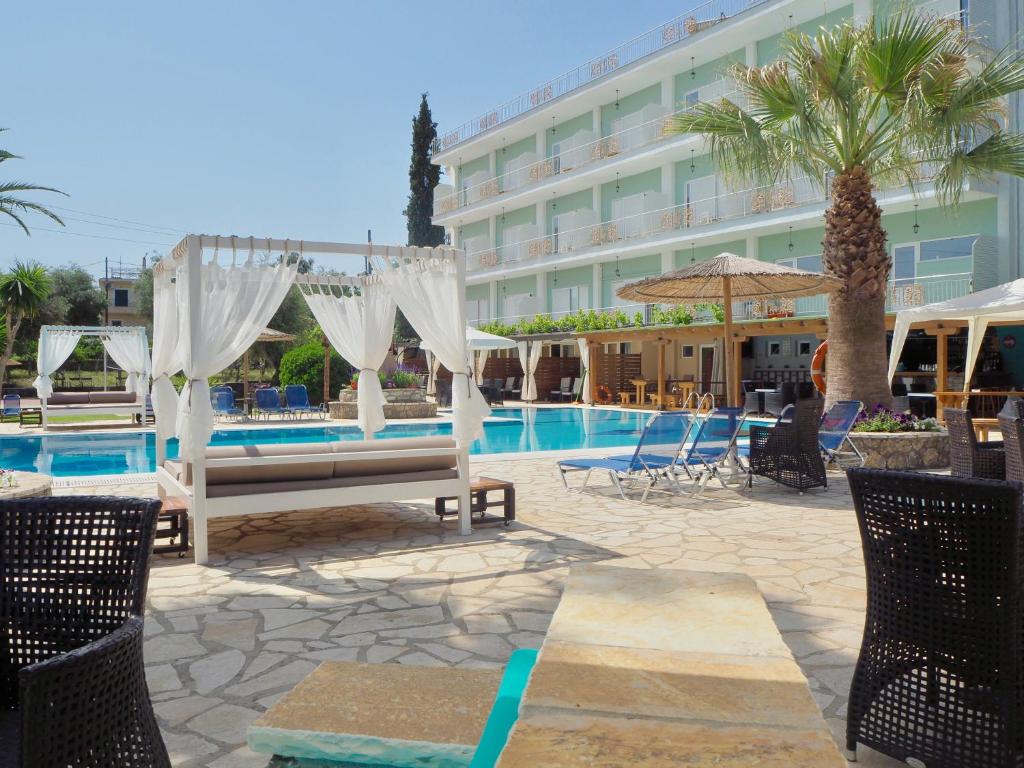 un hôtel avec une piscine et des chaises et un hôtel dans l'établissement Paloma Blanca, à Dassia