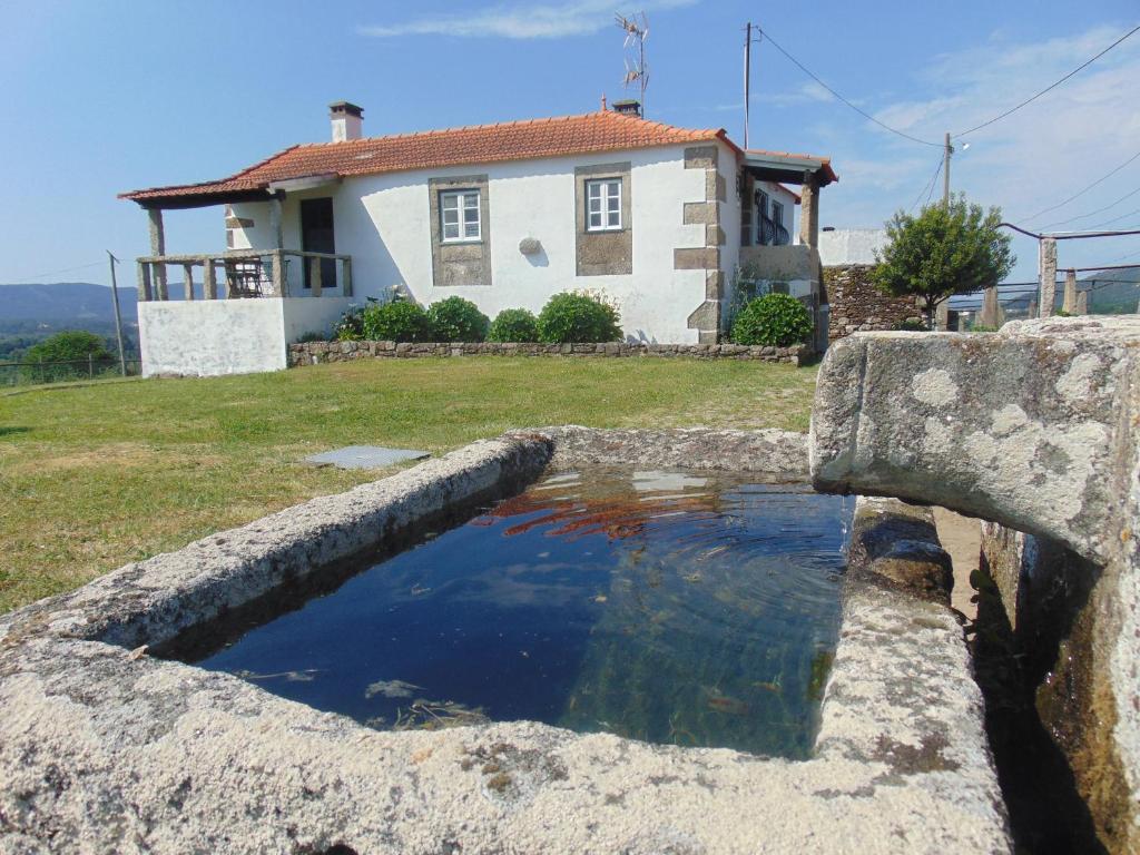 uma piscina de água em frente a uma casa em Casas da Loureira - Casa do António e Pascoal em Vila Nova de Cerveira