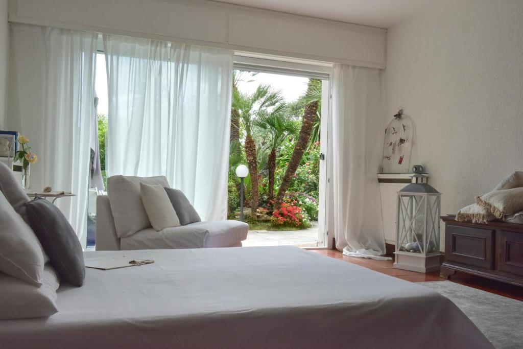 ボルディゲーラにあるLa Via Romana Boutique Guest Houseのベッドとソファと窓のある寝室