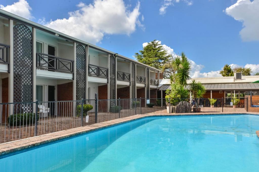 
a large swimming pool in front of a house at Poenamo Hotel in Auckland
