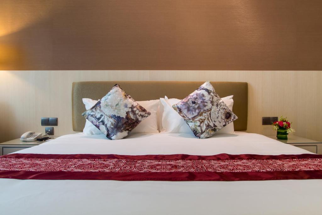 a bed with two stuffed animals on top of it at Imperial Hotel Kuching in Kuching