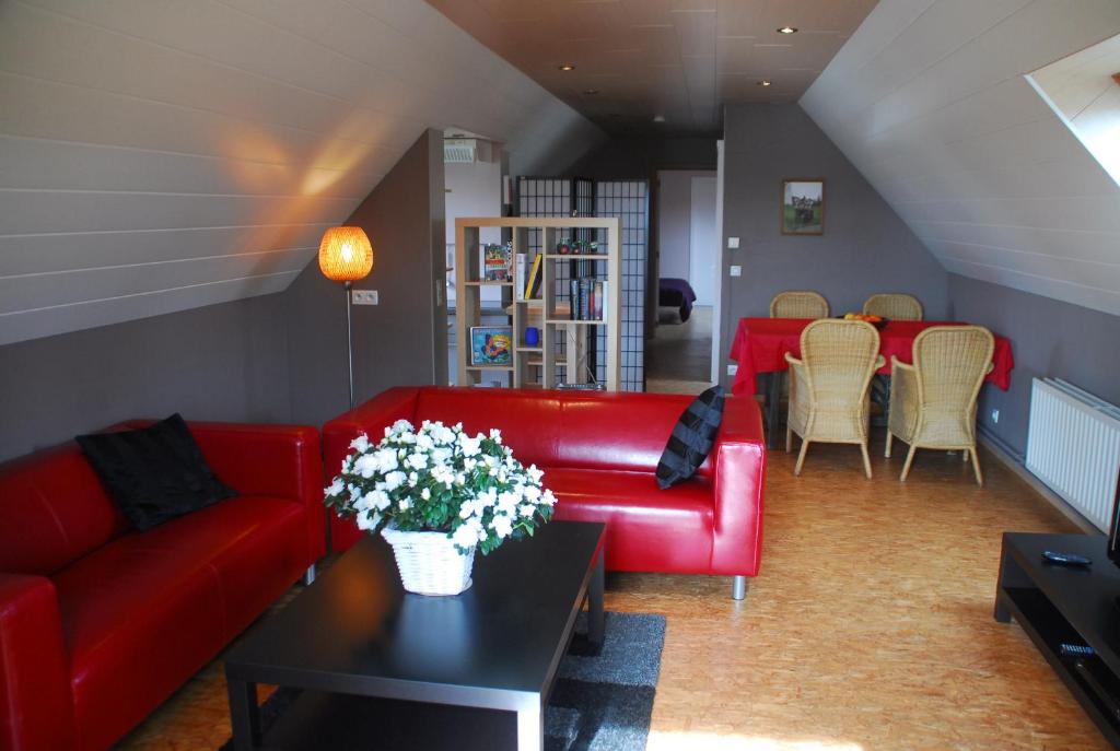 a living room with a red couch and a table at De Rosmolen in Ertvelde