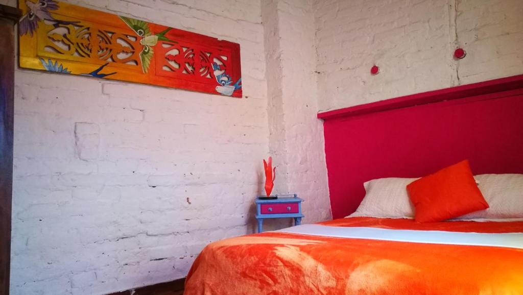 a bedroom with a bed with a red head board at Lima Limon Candelaria Hostel in Bogotá