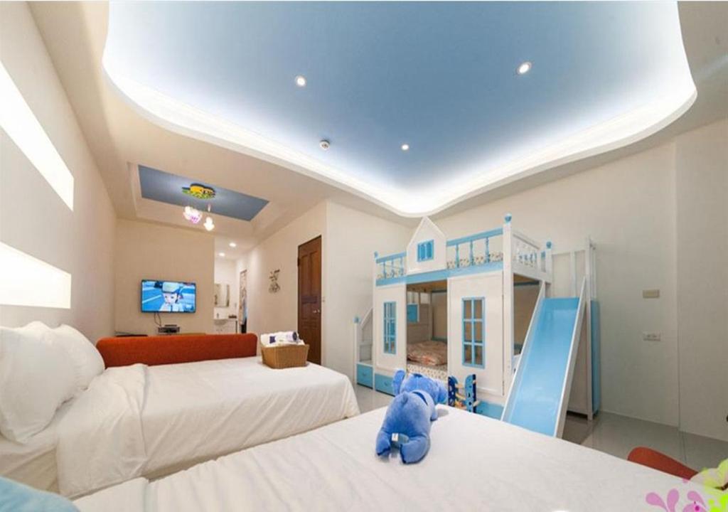 大隱村的住宿－小鎮漫漫民宿，一间卧室,卧室配有一张蓝色泰迪熊,位于两张床上