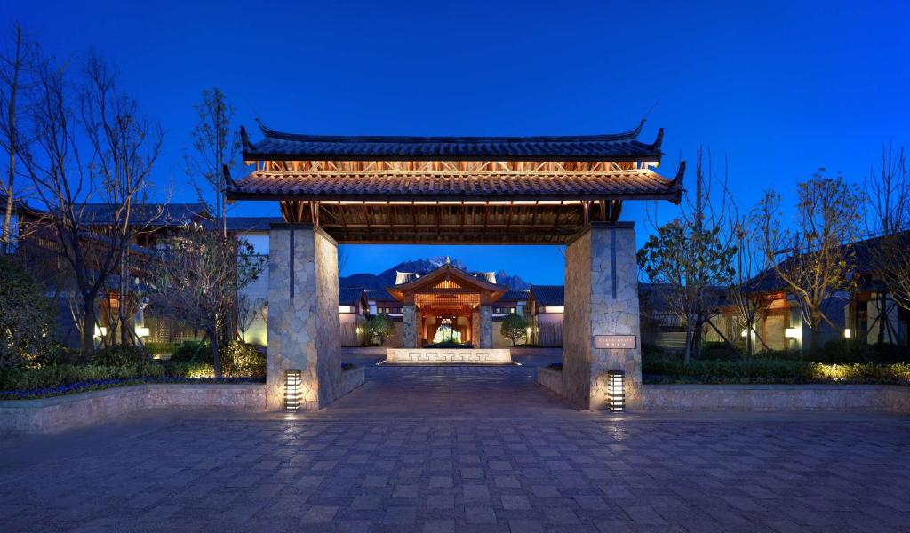 una entrada a un edificio con una puerta por la noche en Jinmao Hotel Lijiang, the Unbound Collection by Hyatt en Lijiang