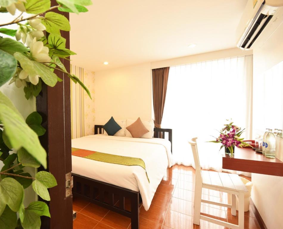 sypialnia z łóżkiem i dużym oknem w obiekcie Blissotel Ratchada w mieście Bangkok