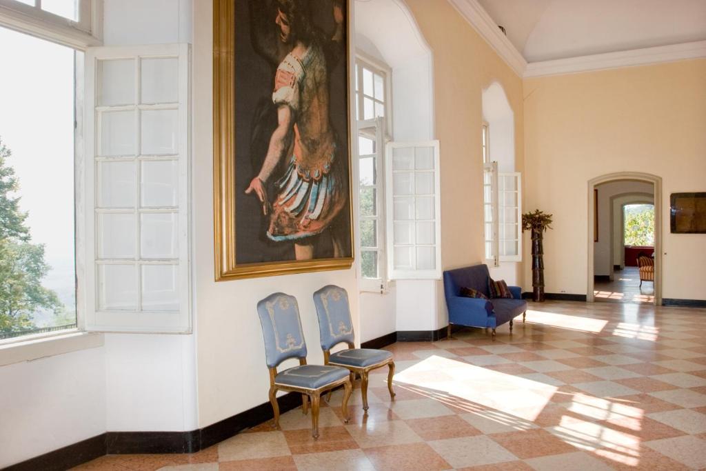 a room with two chairs and a painting on the wall at Castello di Rocca Grimalda in Rocca Grimalda