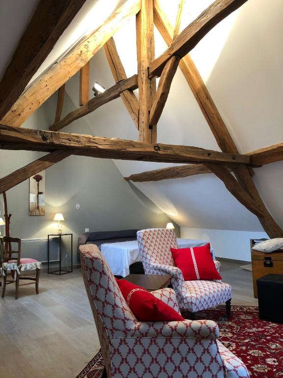 a attic room with two chairs and a bed at Aux Cornettes in Beaune