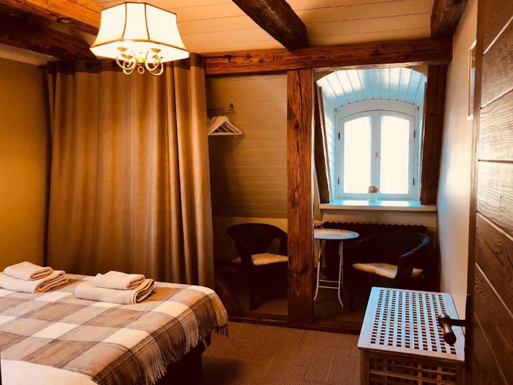 a bedroom with a bed and a window and a table at Fotogrāfa Apartamenti in Kuldīga