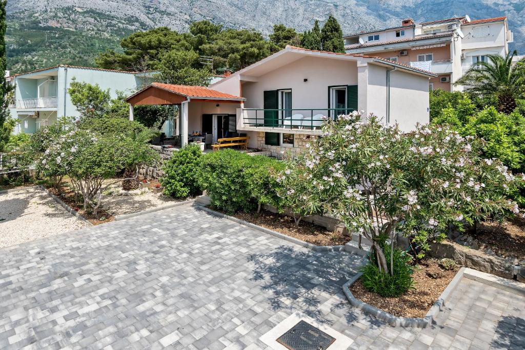 eine Villa mit einem Garten und einem Haus in der Unterkunft Villa Bandic in Baška Voda