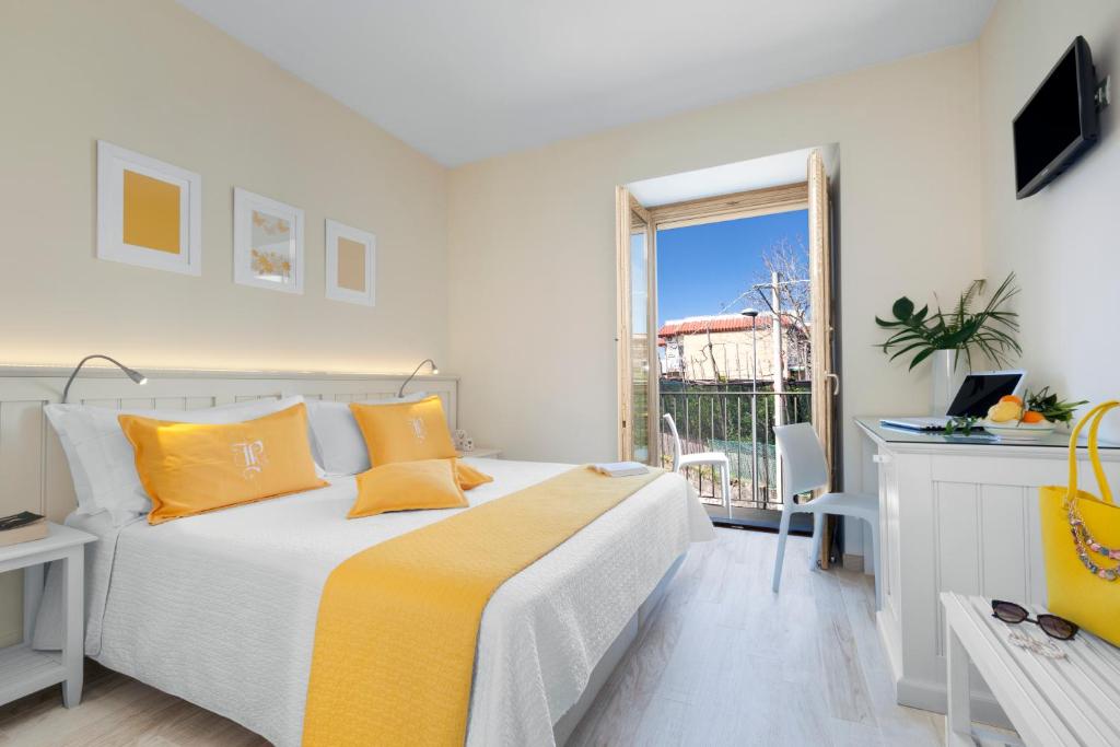 a white bedroom with a bed and a balcony at Il Palmento Relais in Piano di Sorrento