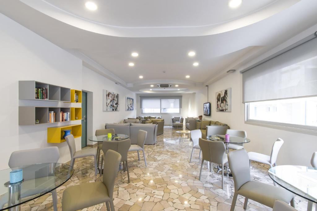 a waiting room with tables and chairs at Hotel Bristol in Caorle